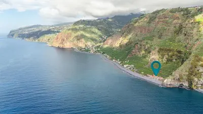 an aerial view of a beach with a blue marker at Sunset Cottage in Ponta do Sol