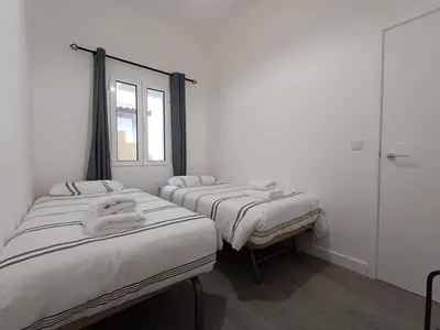 two twin beds in a room with a window at Sunset Cottage in Ponta do Sol
