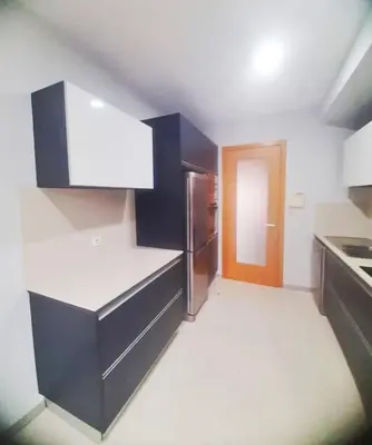 a kitchen with black and white counters and a refrigerator at Private Garden and Pool in the Heart of Funchal in Funchal