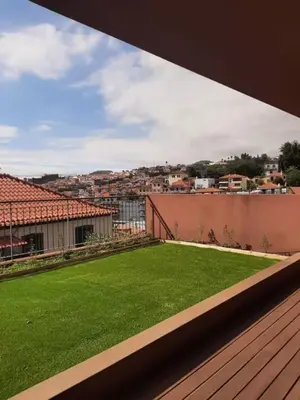 a balcony with a yard of green grass at Private Garden and Pool in the Heart of Funchal in Funchal