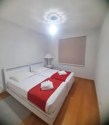 a bedroom with a large bed with a red blanket at Private Garden and Pool in the Heart of Funchal in Funchal