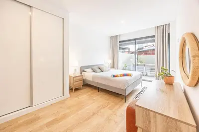 a bedroom with a bed and a large window at Sunny Luxury Apartment Canico in Caniço