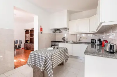 a kitchen with a table with a table cloth on it at Serenity Sao Roque 2 Bedroom House in Funchal with Parking in Funchal