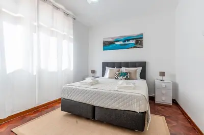 a bedroom with a large bed with white walls at Serenity Sao Roque 2 Bedroom House in Funchal with Parking in Funchal