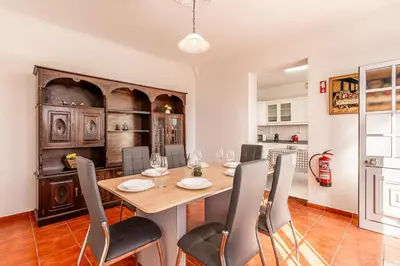 a kitchen and dining room with a table and chairs at Serenity Sao Roque 2 Bedroom House in Funchal with Parking in Funchal