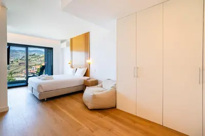 a bedroom with a bed and a chair at GuestReady - Bright home with stunning views in Funchal