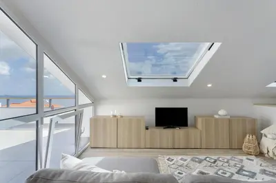 a bedroom with a skylight in the ceiling with a television at Sky and Sea Haven in Santa Cruz