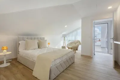 a white bedroom with a large bed and a balcony at Sky and Sea Haven in Santa Cruz