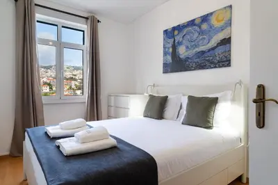 a bedroom with a bed with two towels on it at GuestReady - Wake Up to the Heartbeat of Madeira in Funchal
