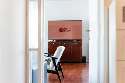a television sitting on top of a dresser with a chair at GuestReady - Wake Up to the Heartbeat of Madeira in Funchal