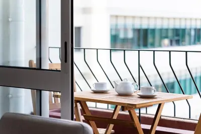 a wooden table with two tea cups on a balcony at GuestReady - Wake Up to the Heartbeat of Madeira in Funchal