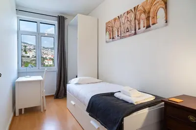 a small bedroom with a bed and a window at GuestReady - Wake Up to the Heartbeat of Madeira in Funchal