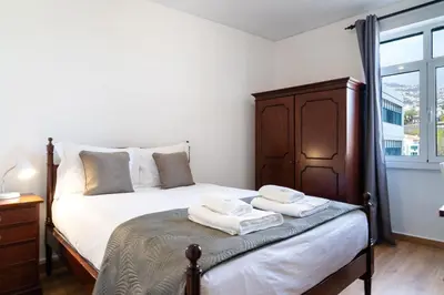 a bedroom with a bed with two towels on it at GuestReady - Wake Up to the Heartbeat of Madeira in Funchal