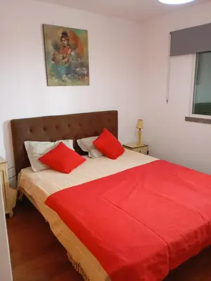 a bedroom with a bed with red pillows on it at Aroma do Mar in Caniço