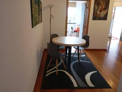 a table and chairs in a room with a rug at Aroma do Mar in Caniço