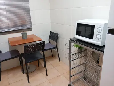 a small kitchen with a table and a microwave at Aroma do Mar in Caniço