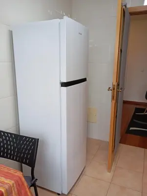 a white refrigerator in a room with a chair at Aroma do Mar in Caniço