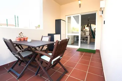 a dining room with a table and chairs on a tile floor at Casa Lobitos Holiday Home with Pool - Sagres in Sagres