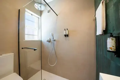 a bathroom with a shower with a glass door at Casa Lobitos Holiday Home with Pool - Sagres in Sagres