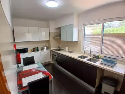 a kitchen with white cabinets and a sink and a window at Al-Solares in Santa Cruz