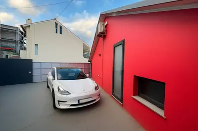 a white car parked next to a red building at Casa Joao Batista em Machico in Machico