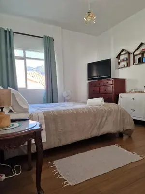 a bedroom with a bed and a dresser and a television at Nature Brava Stay in Ribeira Brava