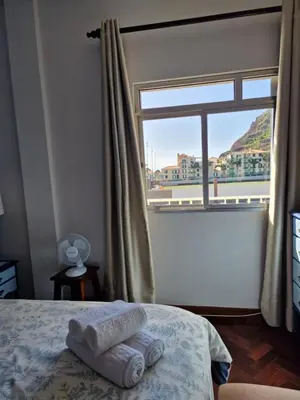 a bedroom with a window with towels on a bed at Nature Brava Stay in Ribeira Brava