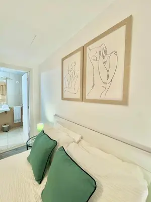 a bedroom with a bed with two green pillows at The West House in Calheta