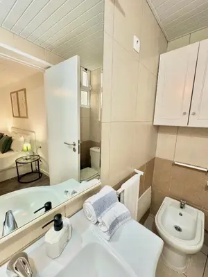 a bathroom with a white sink and a toilet at The West House in Calheta