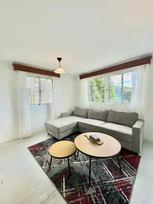 a living room with a couch and two tables at The West House in Calheta