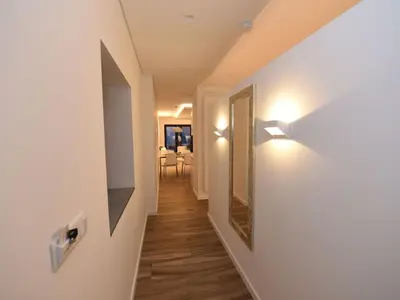 a hallway with white walls and wood floors and a mirror at Quinta Golfinho - Villa Palmeira in Arco da Calheta