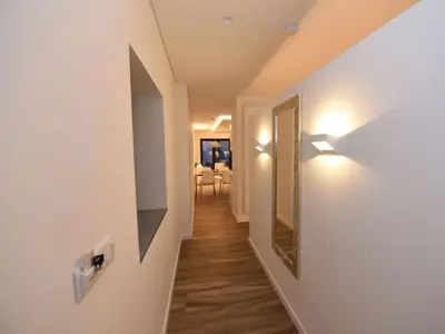 a hallway with white walls and wood floors and a mirror at Quinta Golfinho - Villa Palmeira in Arco da Calheta