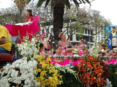 a group of children sitting in pink chairs behind flowers at Quinta Golfinho - Villa Palmeira in Arco da Calheta