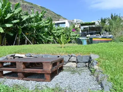 a wooden picnic table in a field of grass at Quinta Golfinho - Villa Rosa in Arco da Calheta