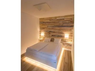 a bed in a room with a wooden wall at Quinta Golfinho - Villa Rosa in Arco da Calheta