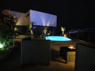 a swimming pool in front of a building at night at Holoiday home Casa Estrelizia in Arco da Calheta