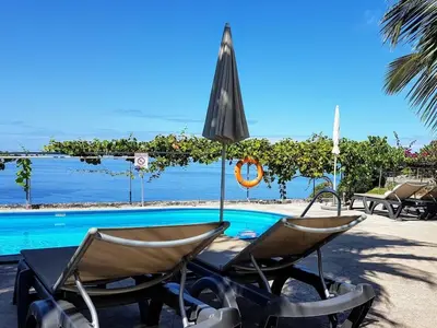 a couple of chairs and an umbrella next to a pool at Holoiday home Casa Estrelizia in Arco da Calheta