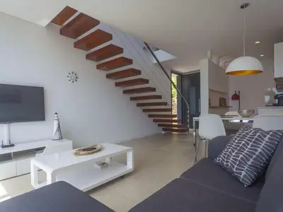 a living room with a couch and a staircase at Holoiday home Casa Estrelizia in Arco da Calheta