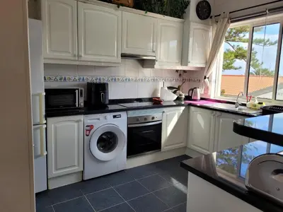 a kitchen with white cabinets and a washer and dryer at SeaView in Porto Santo