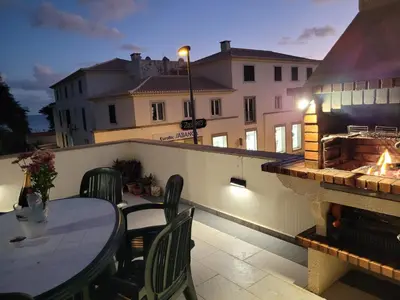 a table and chairs on a balcony with a fire place at SeaView in Porto Santo
