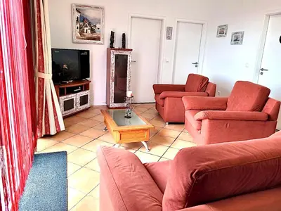 a living room with red couches and a television at SeaView in Porto Santo