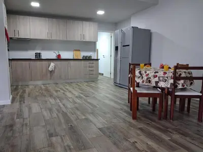 a kitchen with a table and chairs and a refrigerator at Northern Air House in São Vicente