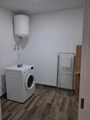 a laundry room with a washing machine and a fan at Northern Air House in São Vicente