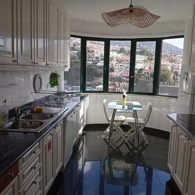 a kitchen with a table and a view of a city at Apartamento Silvestre Freitas in Funchal