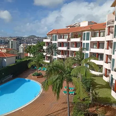 an apartment with a swimming pool and a building at Apartamento Silvestre Freitas in Funchal