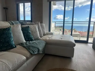 a white couch in a living room with windows at H&F Fort View Apartment in Funchal