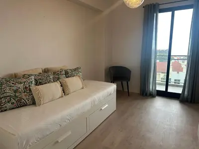 a white couch in a room with a large window at H&F Fort View Apartment in Funchal