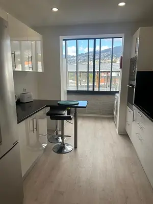 a kitchen with a desk and a table in a room at H&F Fort View Apartment in Funchal