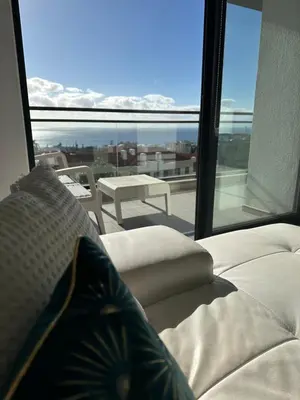 a living room with a couch and a large window at H&F Fort View Apartment in Funchal