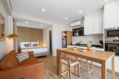 a living room with a kitchen and a bedroom at Modern Studio Steps From Beach in Ponta do Sol